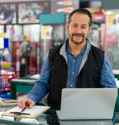 Small business owner behind counter in his hardware store.
