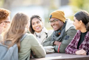 Friends chatting at a picnic table.