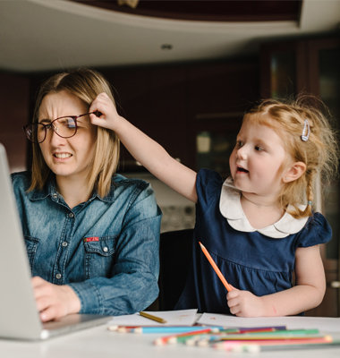 Mother working from home being distracted by her young daughter.