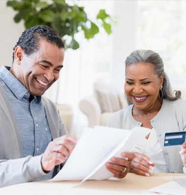 Mature couple reviewing credit card rewards statement.