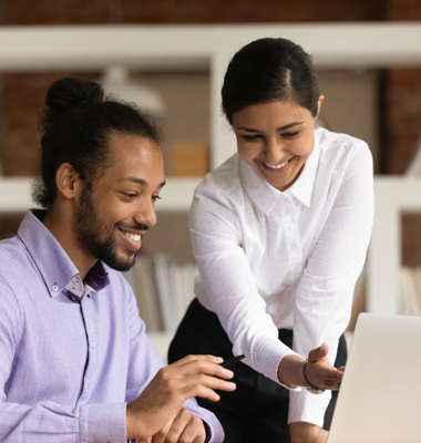 Woman providing assistance to man on computer.