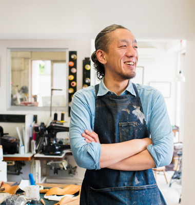 Shop owner smiling and looking out window.