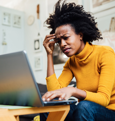 Young woman at laptop trying to remember password.