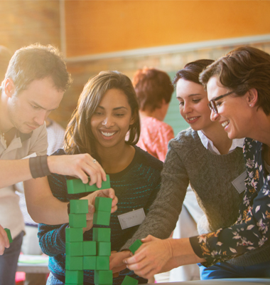 Coworkers enjoying team exercise using blocks.
