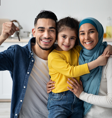 Young father, mother and daughter celebrating moving into new home. Father holding up key.