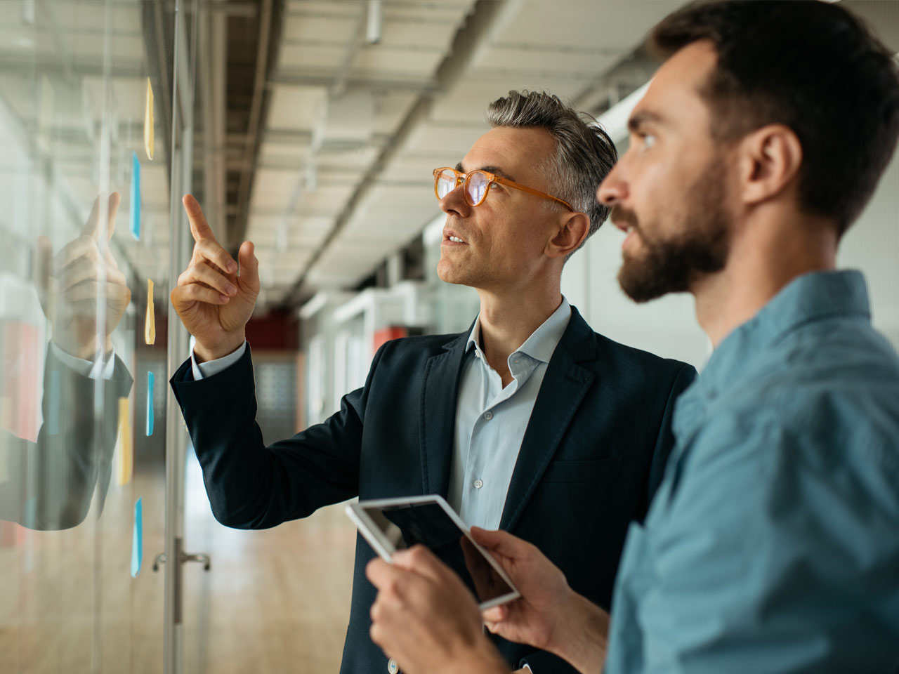 Two serious businessman looking at a development plan.