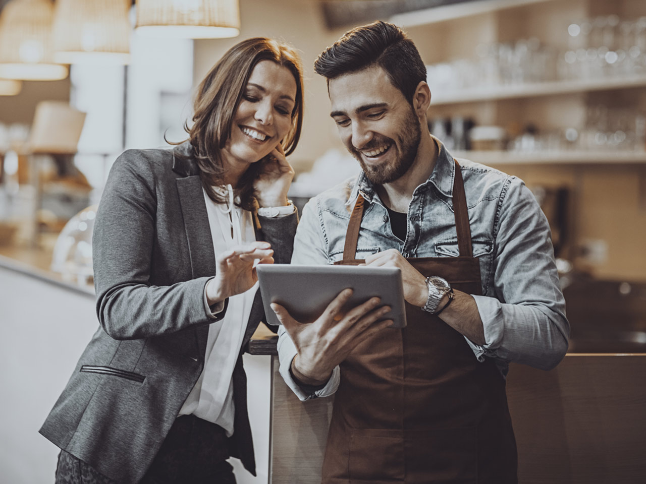 Manager and business owner reviewing account info on iPad.