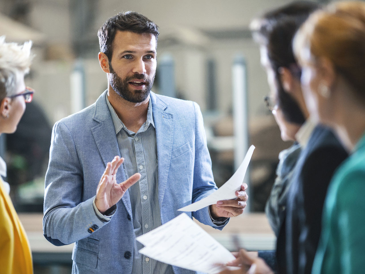 Business owner and management team discussing company expansion