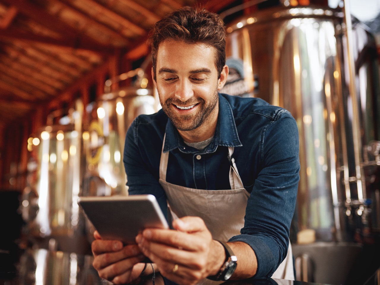 Young brewery owner checking inventory on smart tablet.