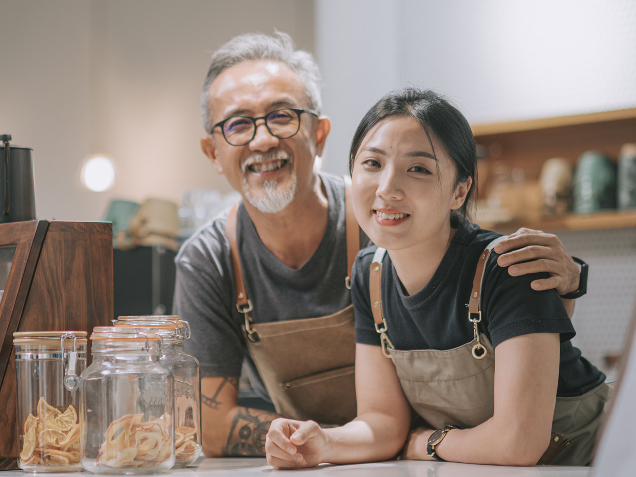 Father and daughter business owners at counter of their coffee bar.