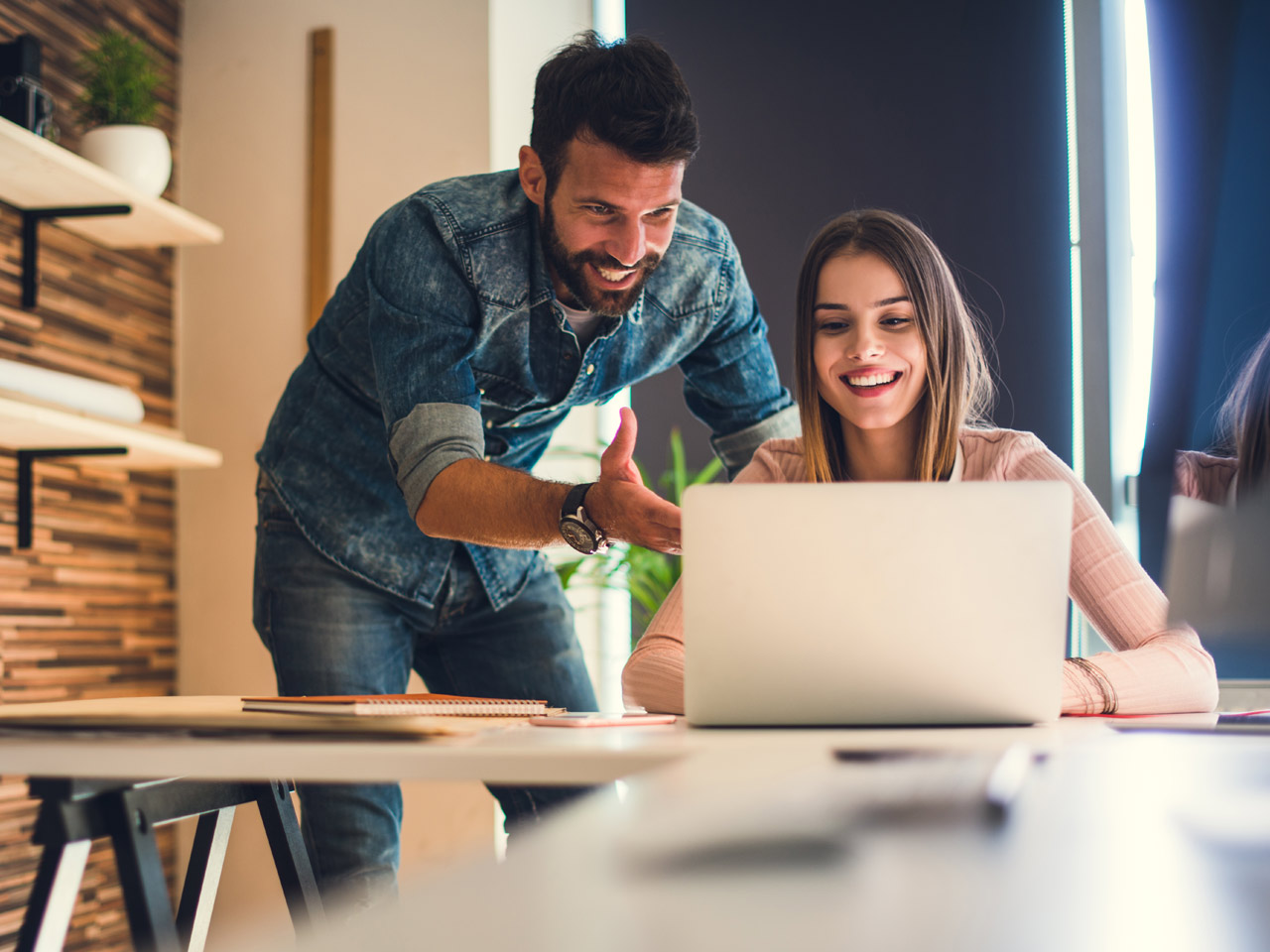 Young male and female business owners working on laptop.