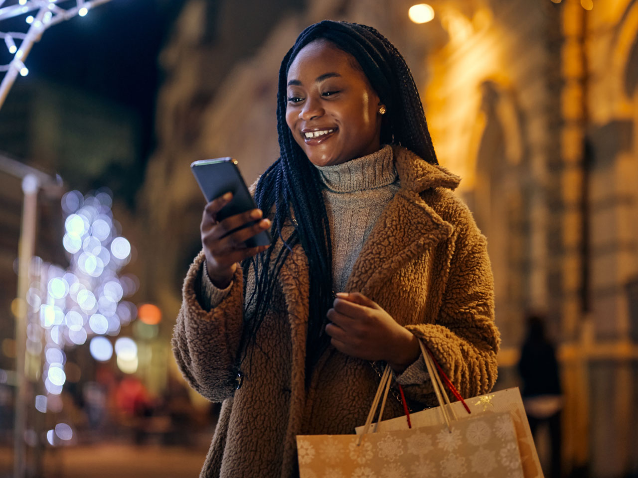 Young woman out shopping and texting on smartphone.