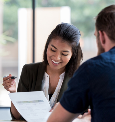 Financial advisor assisting a customer in a brightly lit office.