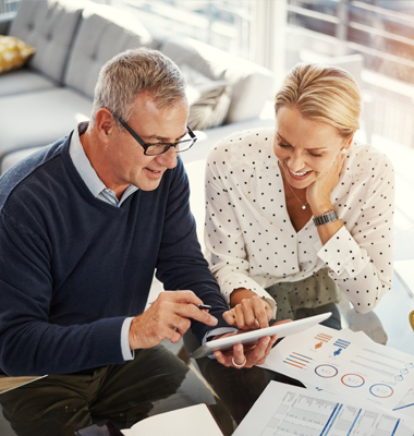 Mature couple reviewing financial information at home.