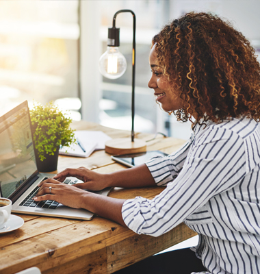 Young female freelancer entering invoices on her laptop.