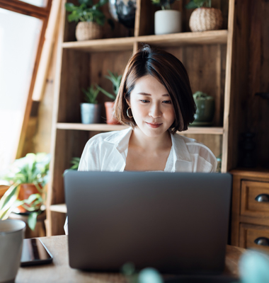 Young woman calculating business finances on laptop.