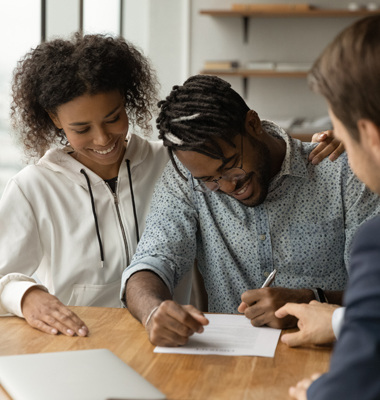 Young couple signing loan agreement.