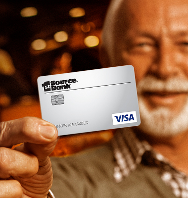 Mature gentleman holding up 1st Source Platinum VISA Credit Card