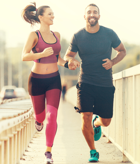 Fit man and woman running across a bridge.