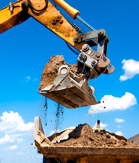 Excavator loading dirt into a dump truck.