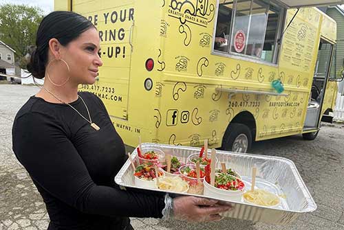 woman holding tray of food outside food truck