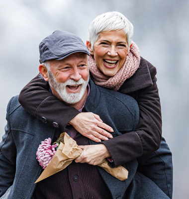 Elderly woman and husband laughing in the park.