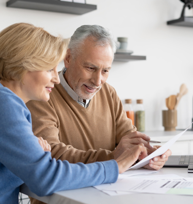 Mature couple balancing their checking account at the kitchen table.