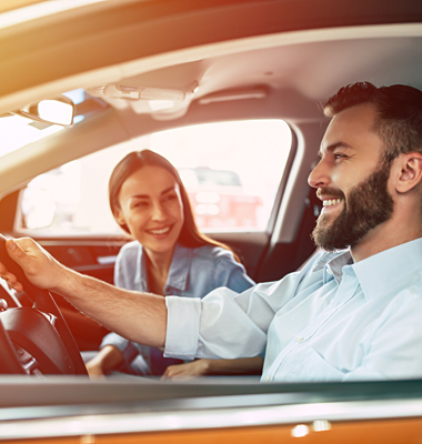Young couple test-driving a new car.