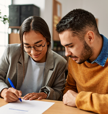 Young couple sitting at dining table comparing mortgage payments.