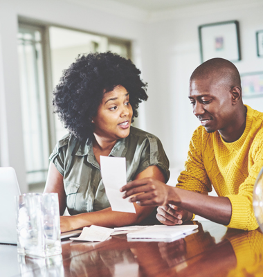 Couple sitting at the dining room table going over receipts and bills.