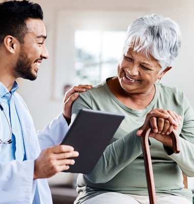 Older woman holding walking cane meeting with physician.