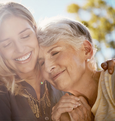 Grown daughter hugging her elderly mother.