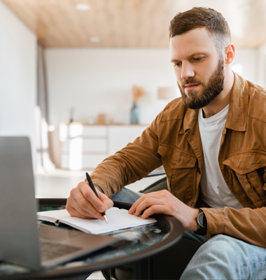 Young man reviewing financial data on laptop at home.