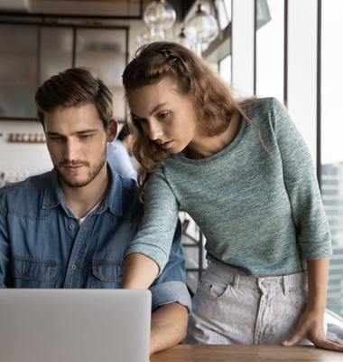 Young couple reviewing finances on laptop.