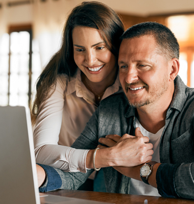 Husband and wife reviewing the monthly budget on laptop.
