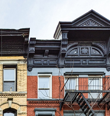 Detail view of roof and windows of an old townhouse.