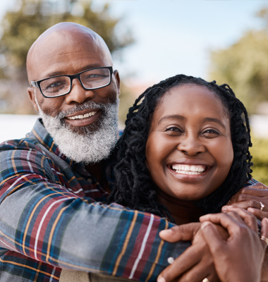 Middle-age couple hugging and laughing.