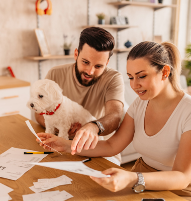 Couple at home with dog going over finances.