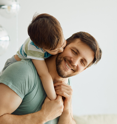 Young father at home playing with toddler son.