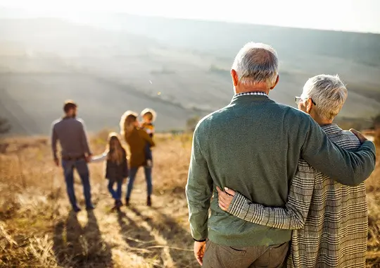 older couple observing young family