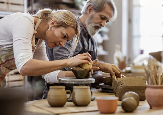 man and woman working with pottery