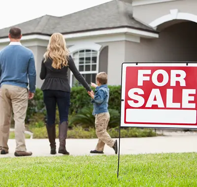 A happy family standing together in front of a house with a