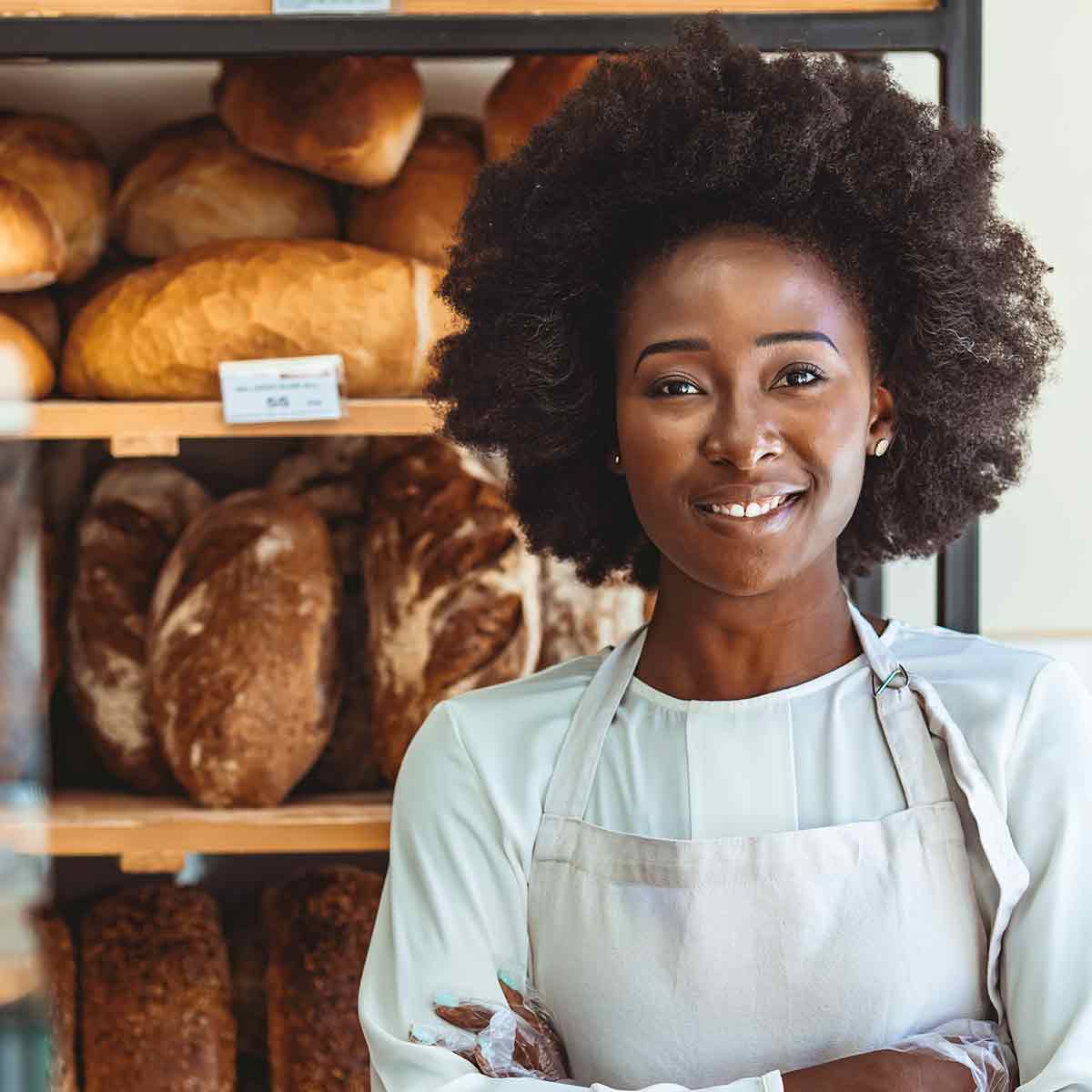 A joyful black woman in a bakery, radiating happiness as she smiles