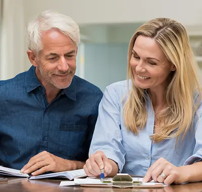 A man and woman sitting at a table, reviewing paperwork