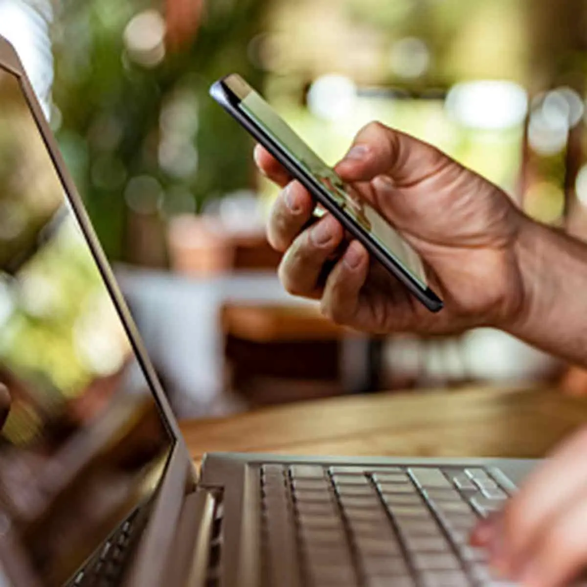 Closeup of using a smart phone to complete an online payment on the computer with a digital wallet