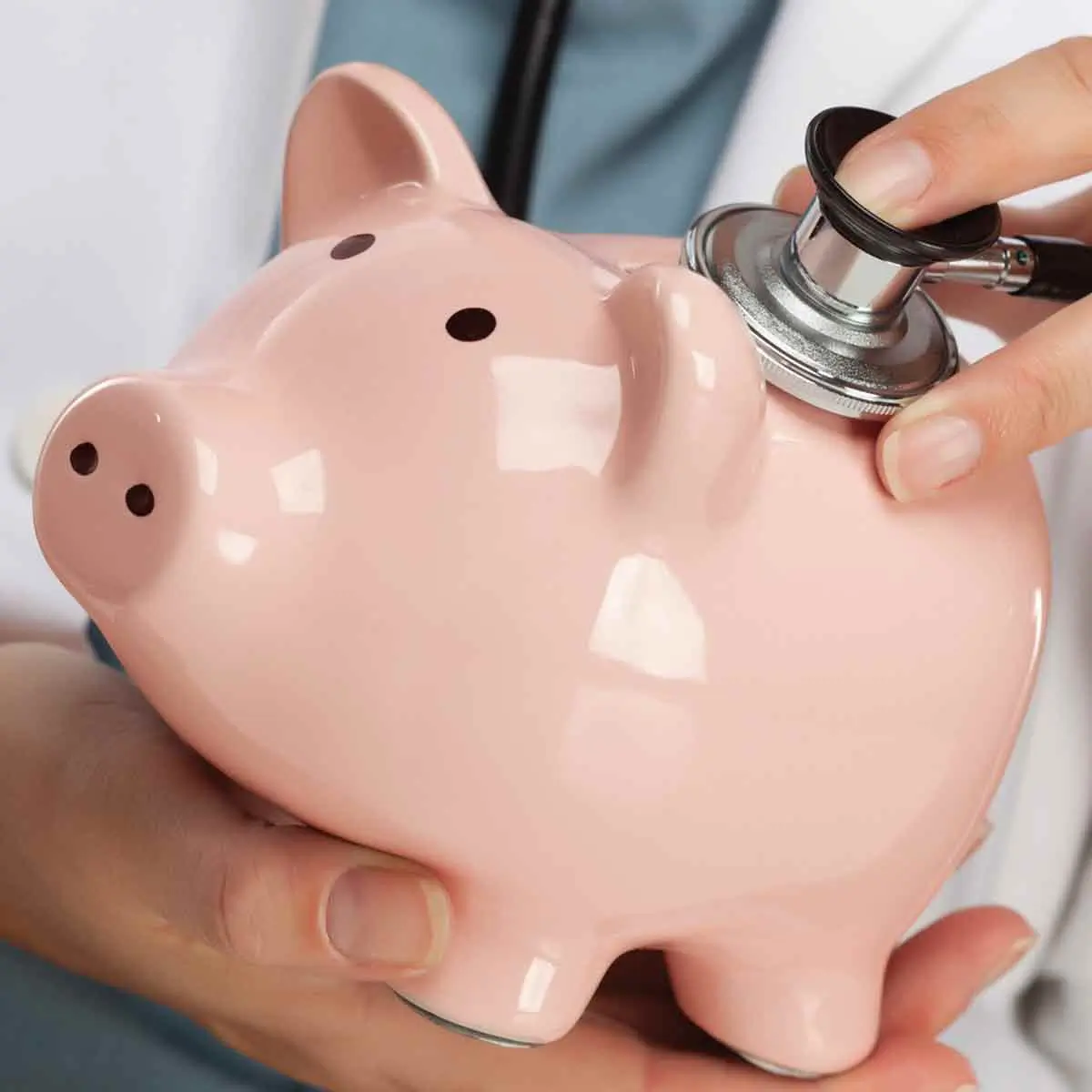 Stethoscope checking a piggy bank representing high-deductible health plans (HDHP) and healthcare savings plans