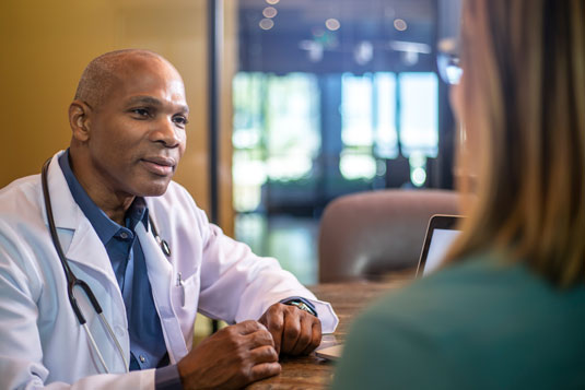 A doctor and a banker engage in a discussion about financial matters in the doctor's office.