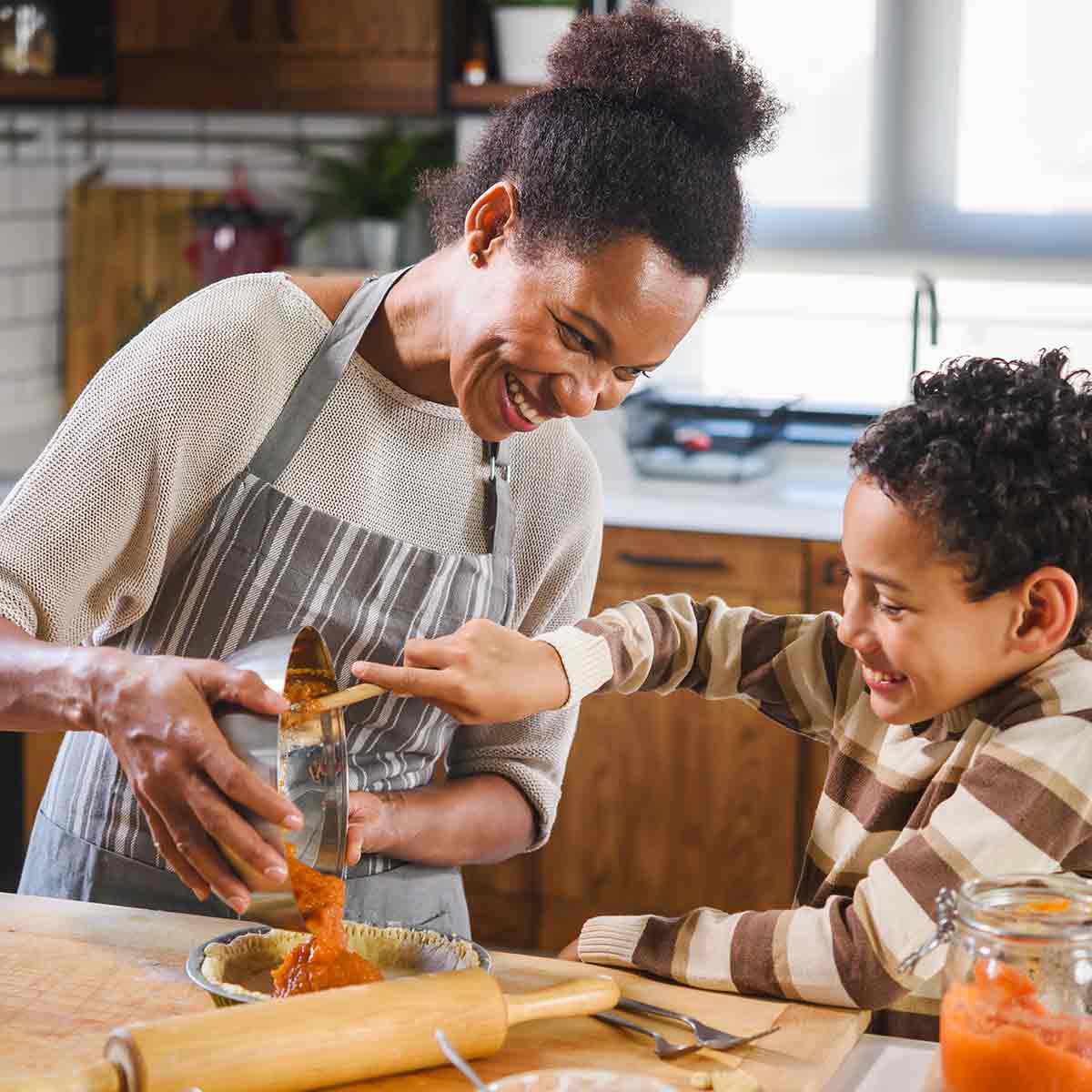 Mother and son making a Thanksgiving pie, symbolizing financial planning and family budgeting