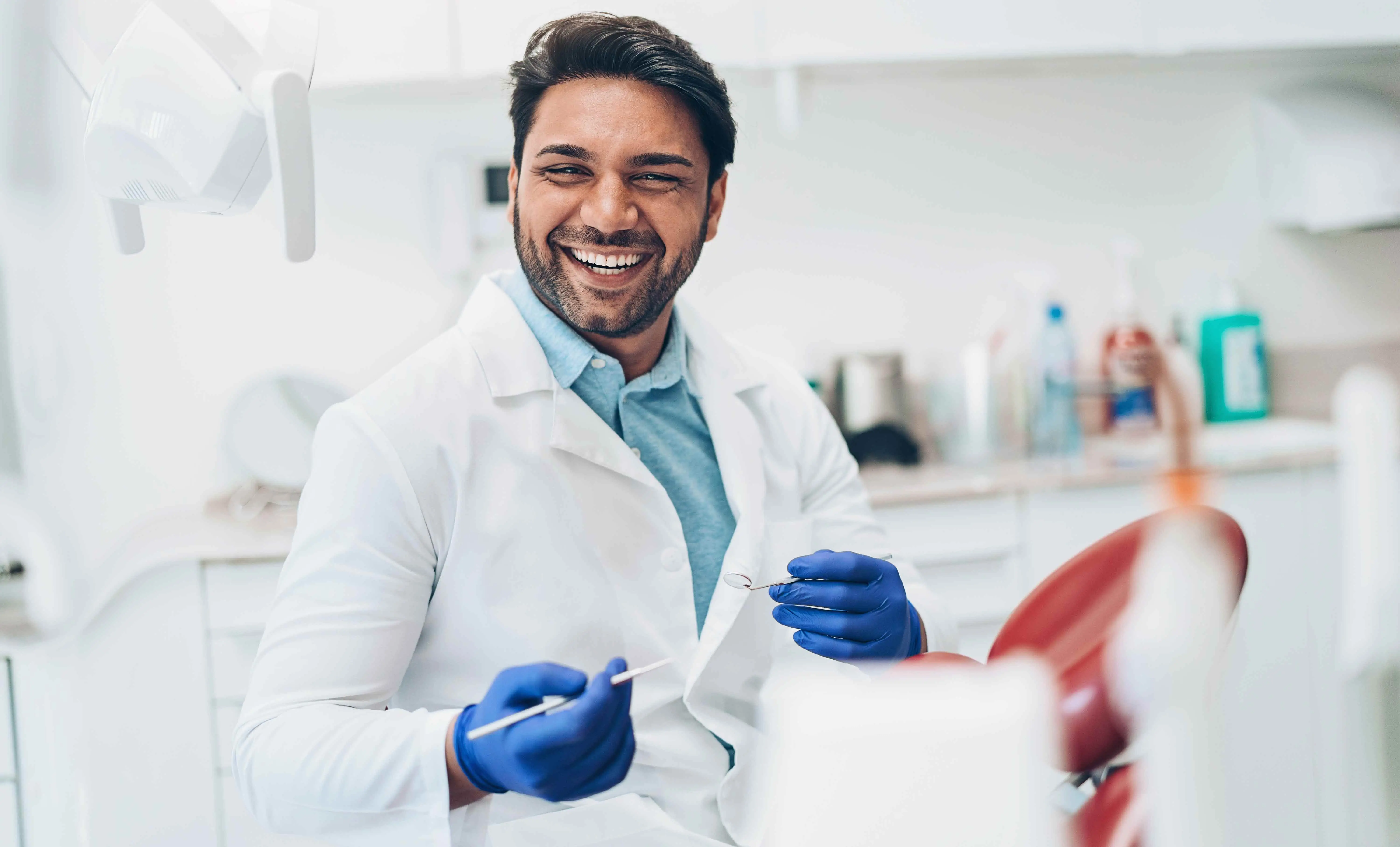 Dentist looking up from dental work and smiling, conveying a friendly and professional environment for patient care in his Indiana dental office