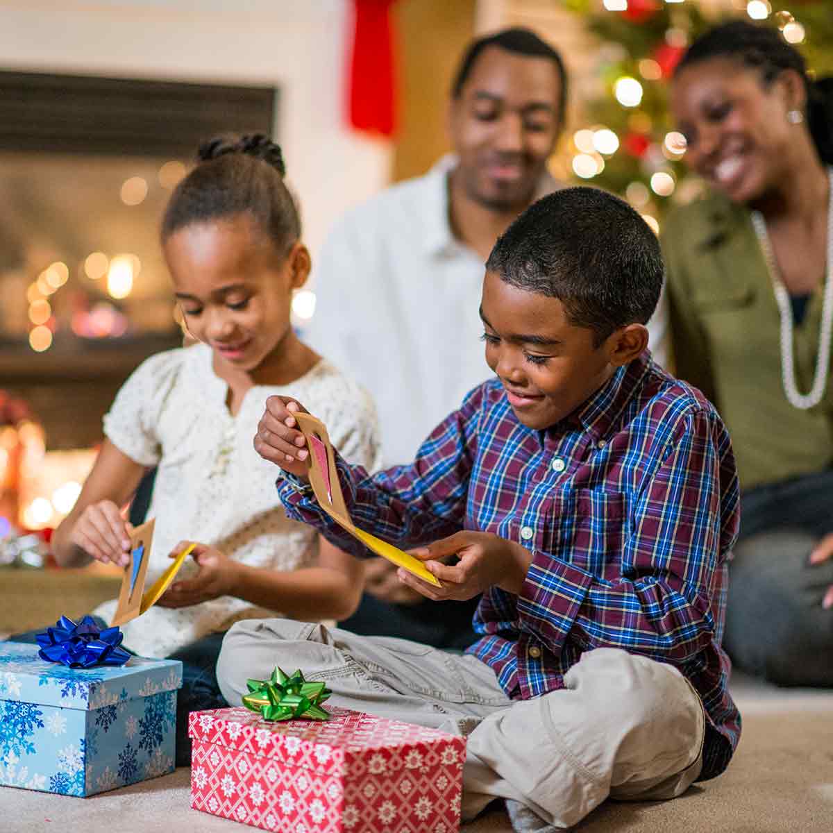 Family opening presents by the Christmas tree. Besides toys, they are and investing in children's future with savings accounts and 529 plans.